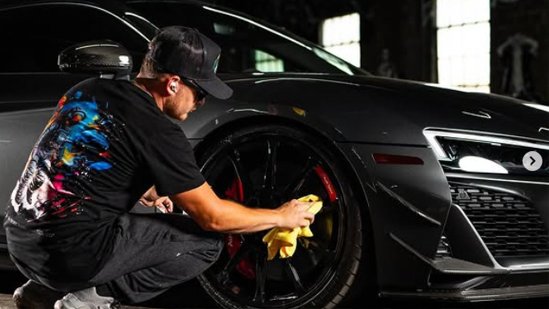 Jay R Bees detailer wiping down the wheel of a black Audi R8