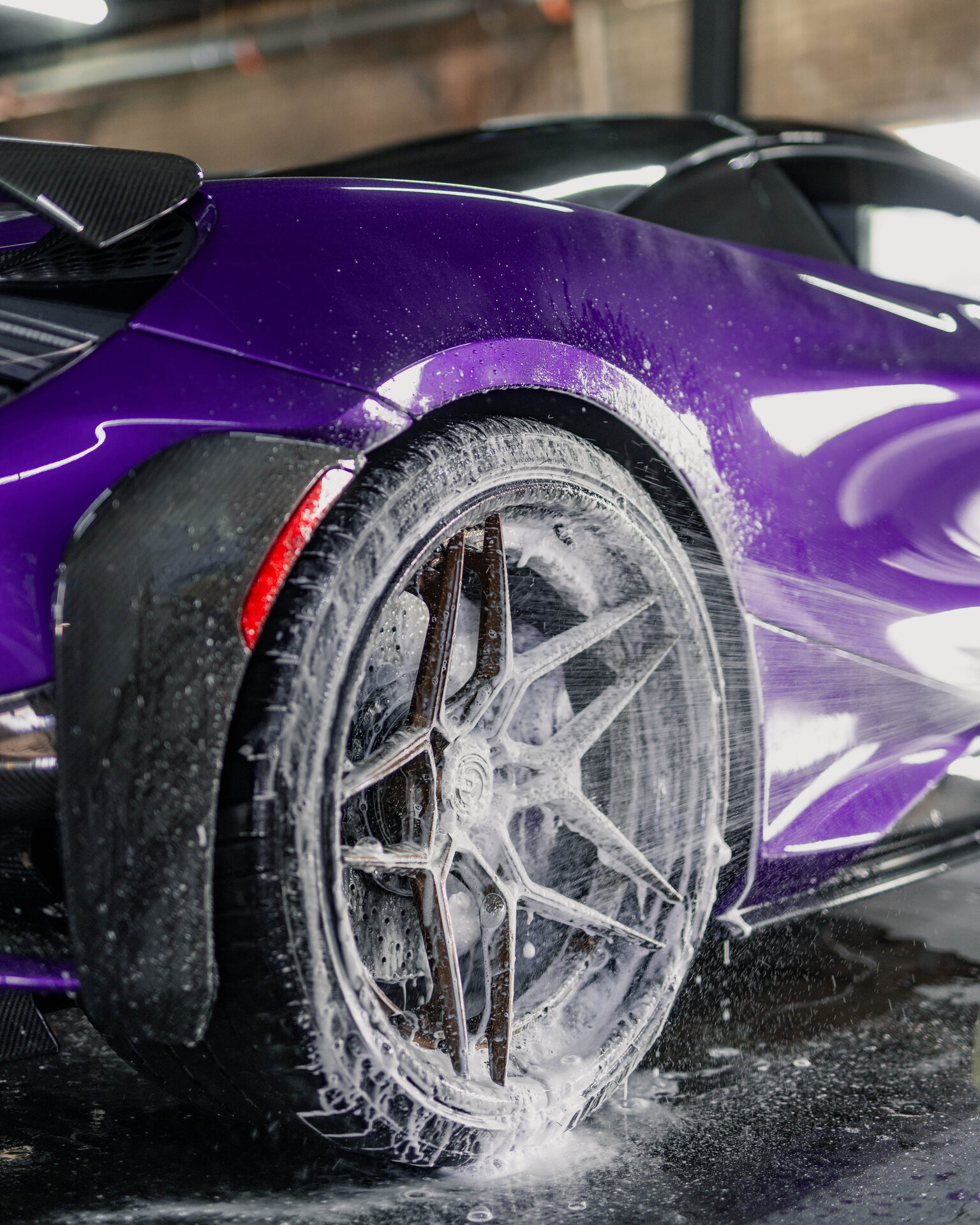 High-pressure rinse revealing a spotless finish on a luxury vehicle